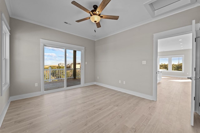 empty room with crown molding, visible vents, a wealth of natural light, and light wood-type flooring