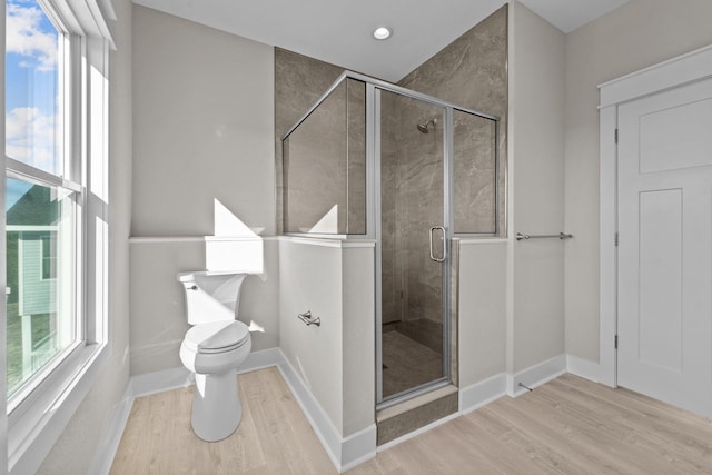 full bathroom with toilet, wood finished floors, a stall shower, and baseboards