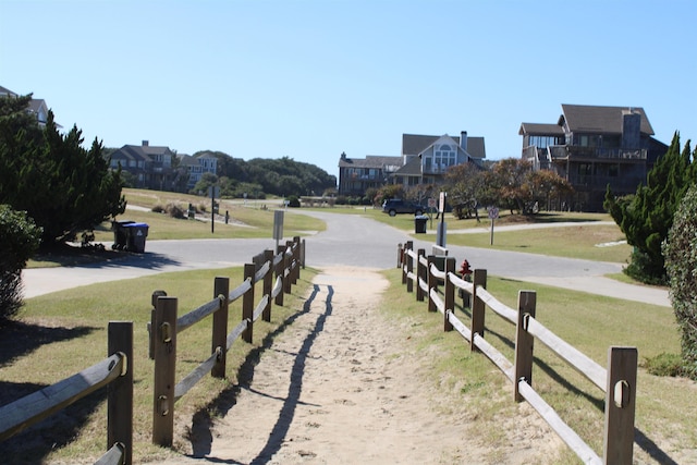 view of community featuring fence and a yard