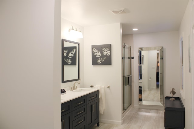 bathroom with a stall shower, baseboards, visible vents, and vanity