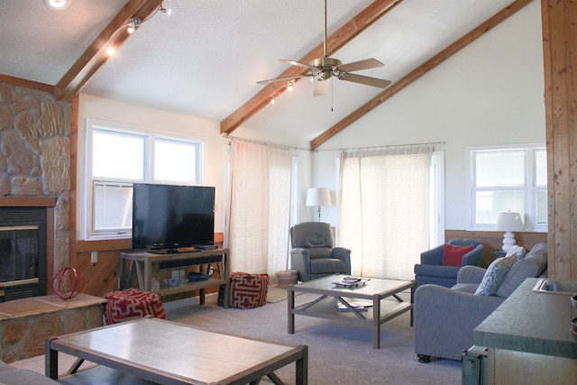 living area with a stone fireplace, a textured ceiling, carpet flooring, high vaulted ceiling, and beam ceiling