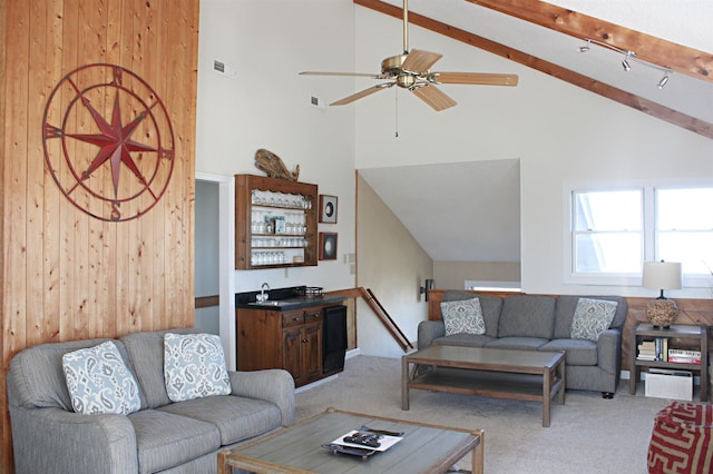 living area featuring visible vents, light colored carpet, ceiling fan, beamed ceiling, and indoor wet bar