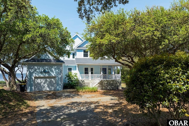 view of front of house with a garage, driveway, a porch, and stairs