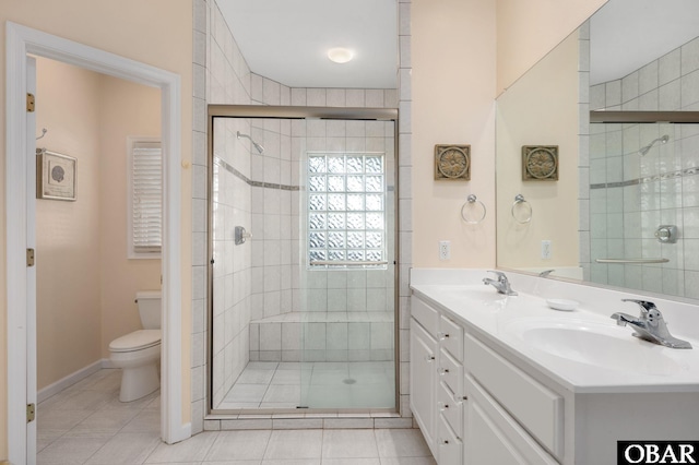 bathroom with double vanity, a stall shower, toilet, tile patterned floors, and a sink