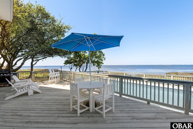 wooden deck featuring area for grilling, a water view, and a view of the beach