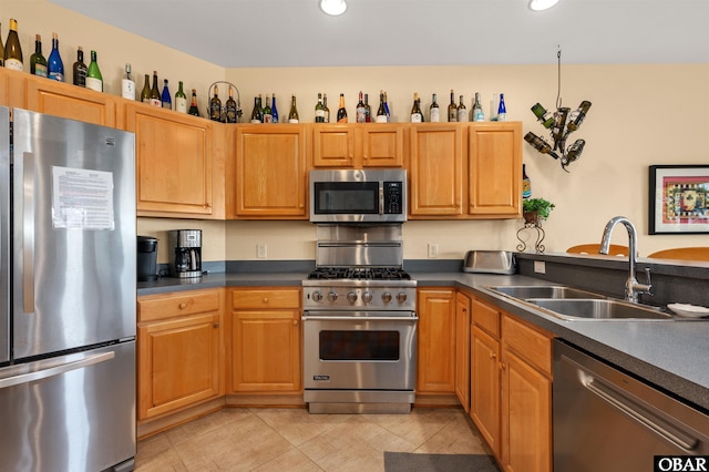 kitchen with appliances with stainless steel finishes, dark countertops, a sink, and recessed lighting