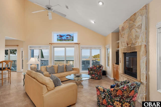 living area featuring recessed lighting, visible vents, a ceiling fan, a stone fireplace, and high vaulted ceiling