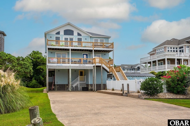 view of front of property with stairs, concrete driveway, and fence