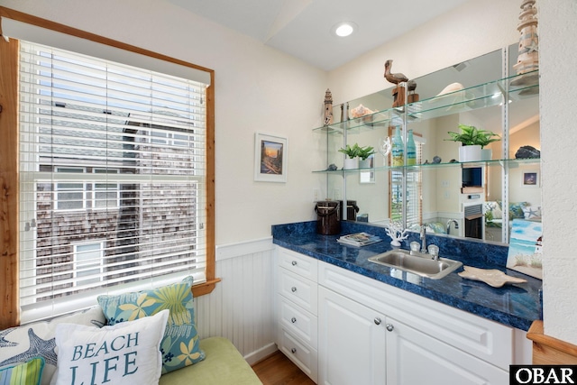 bathroom with wainscoting, wood finished floors, vanity, and recessed lighting