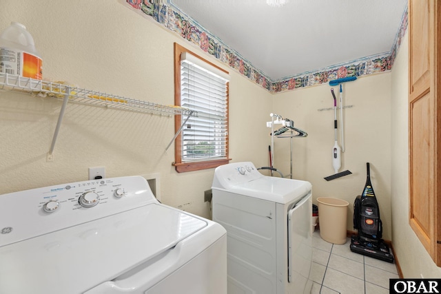 laundry room with laundry area, washer and dryer, and light tile patterned flooring