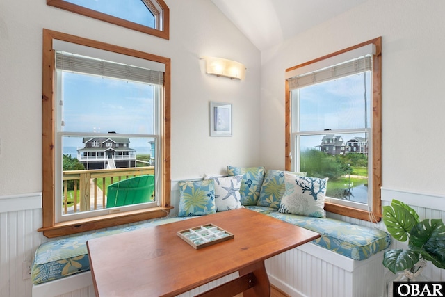 home office with vaulted ceiling, wainscoting, and a healthy amount of sunlight