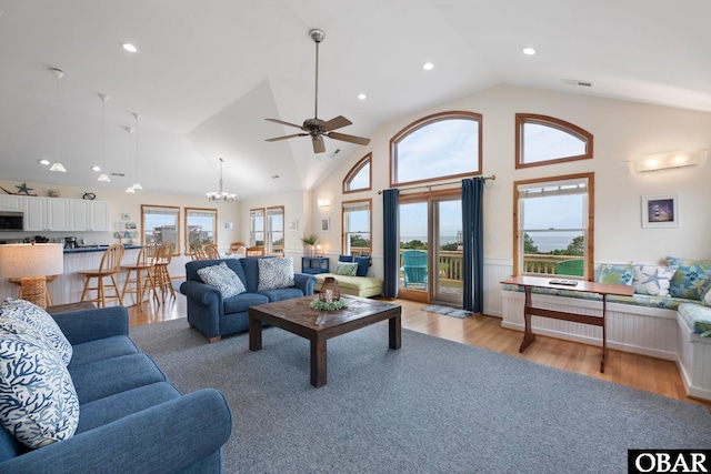 living room with high vaulted ceiling, light wood-style flooring, visible vents, and recessed lighting