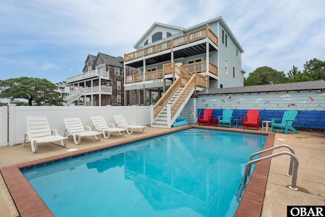 view of swimming pool featuring a patio, stairway, fence, and a fenced in pool