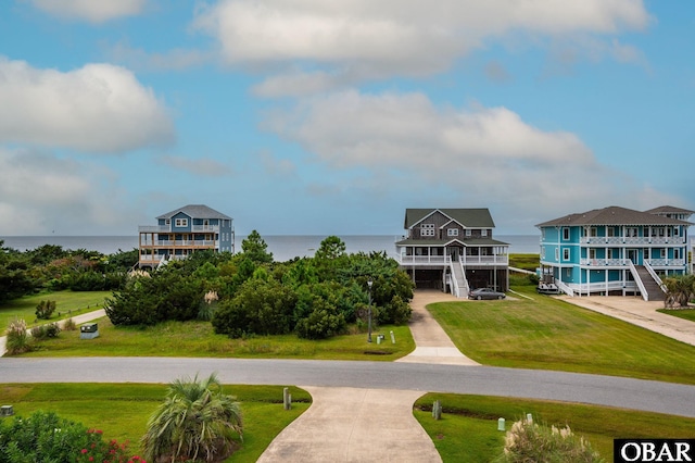 view of home's community with a water view and a yard