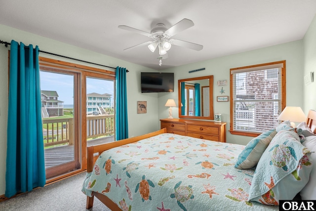 carpeted bedroom featuring access to outside, multiple windows, and ceiling fan