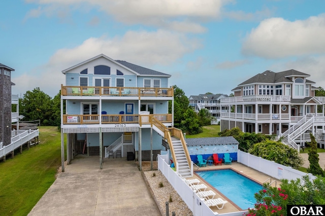 back of property with a fenced in pool, a fenced backyard, stairs, and a lawn