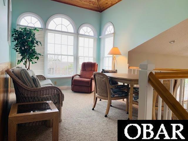 carpeted home office with vaulted ceiling