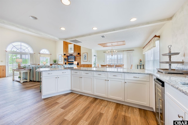 kitchen featuring light wood-style floors, wine cooler, and a wealth of natural light