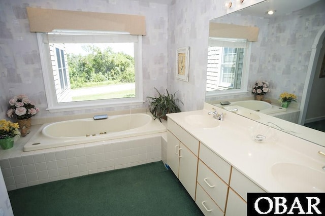 full bath with double vanity, wallpapered walls, a tub with jets, and a sink