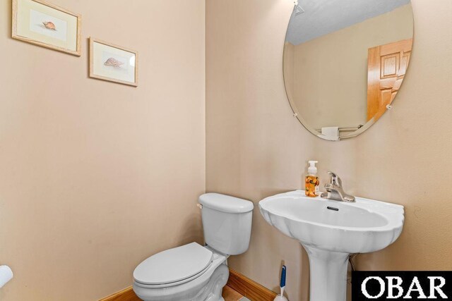 half bathroom with toilet and baseboards