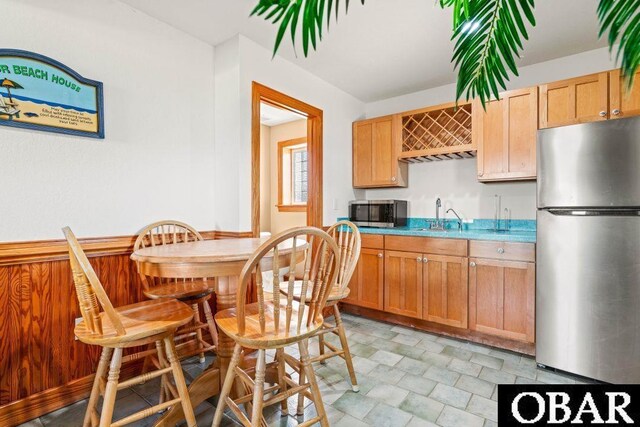 kitchen featuring stainless steel appliances, stone finish floor, a sink, and light countertops