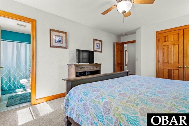 bedroom featuring light carpet, a ceiling fan, visible vents, baseboards, and ensuite bath