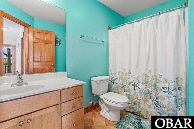 bathroom featuring baseboards, vanity, toilet, and tile patterned floors