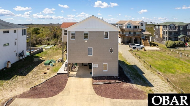 rear view of house with driveway, a residential view, and fence