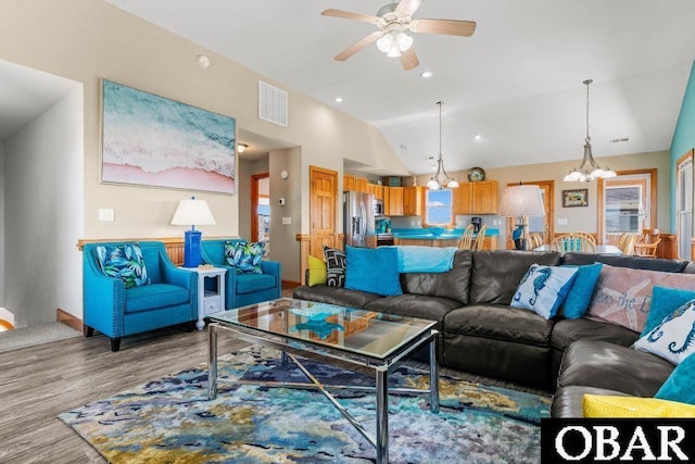 living area with lofted ceiling, recessed lighting, visible vents, light wood-style floors, and ceiling fan with notable chandelier