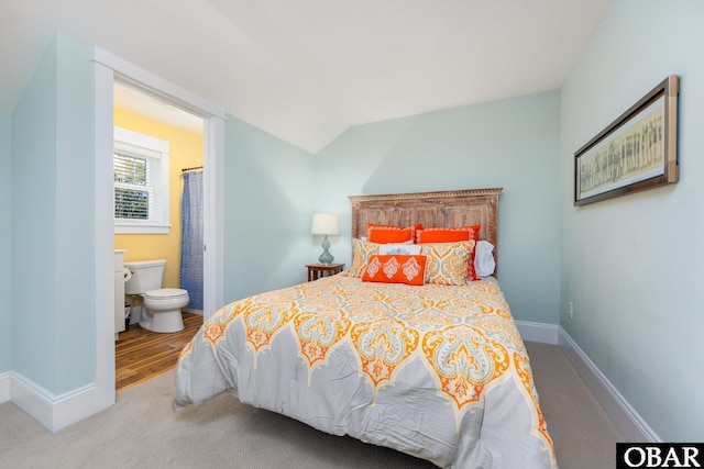 bedroom with lofted ceiling, carpet flooring, connected bathroom, and baseboards