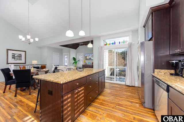 kitchen featuring light wood-style floors, appliances with stainless steel finishes, a breakfast bar area, and a center island