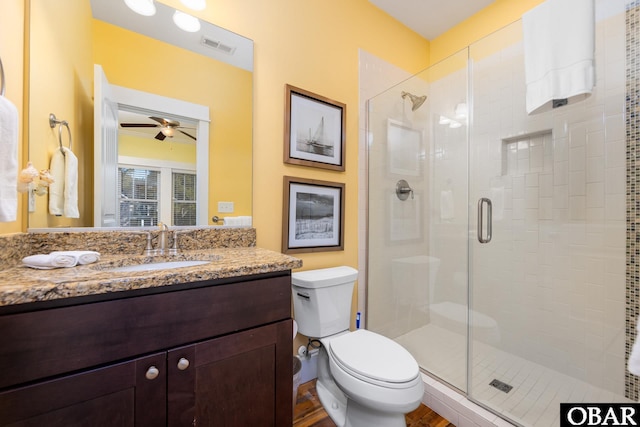 bathroom featuring toilet, a shower stall, visible vents, and vanity