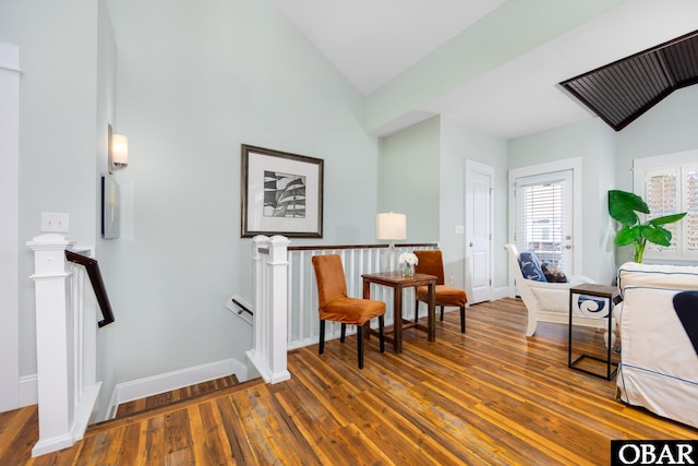 sitting room featuring lofted ceiling, hardwood / wood-style flooring, and an upstairs landing