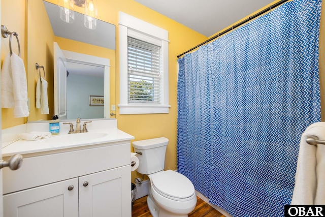 full bathroom with toilet, curtained shower, wood finished floors, and vanity