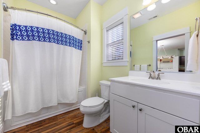 bathroom featuring visible vents, toilet, shower / bath combo, vanity, and wood finished floors