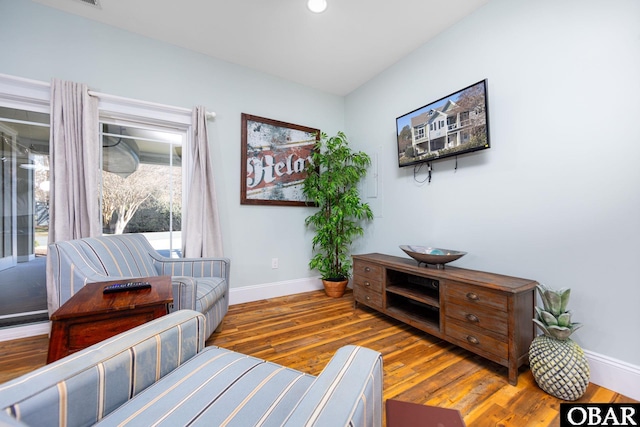 sitting room featuring baseboards, wood finished floors, and recessed lighting