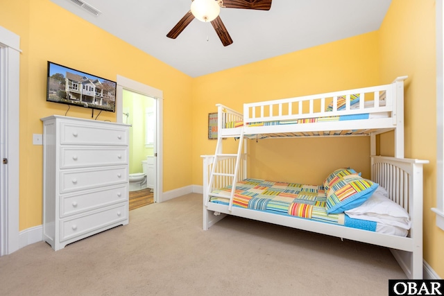 bedroom with ensuite bathroom, ceiling fan, carpet flooring, visible vents, and baseboards