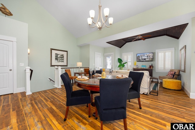 dining area featuring a notable chandelier, vaulted ceiling, and wood finished floors