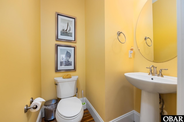 bathroom featuring a sink, toilet, and baseboards