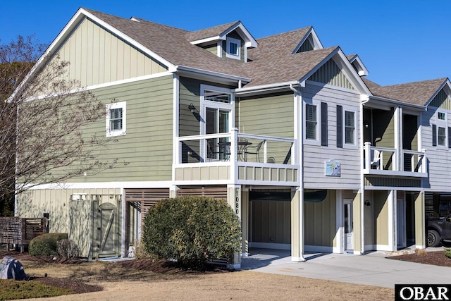 view of front of home with a balcony, a shingled roof, and board and batten siding