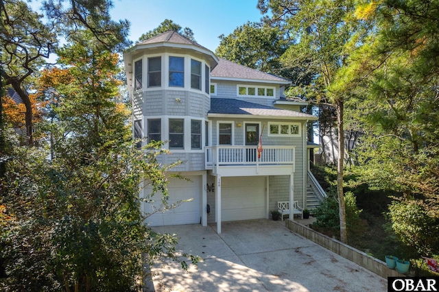 view of front of house featuring an attached garage, fence, concrete driveway, stairway, and roof with shingles