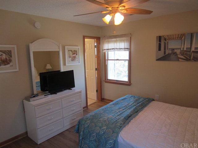 bedroom with ceiling fan, baseboards, and wood finished floors