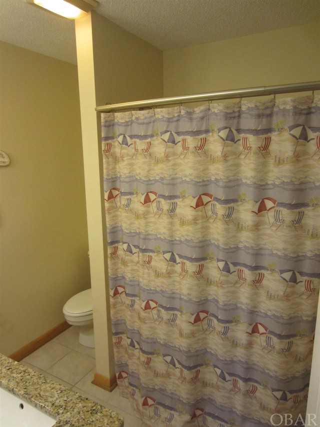 full bathroom featuring toilet, a textured ceiling, vanity, tile patterned flooring, and baseboards