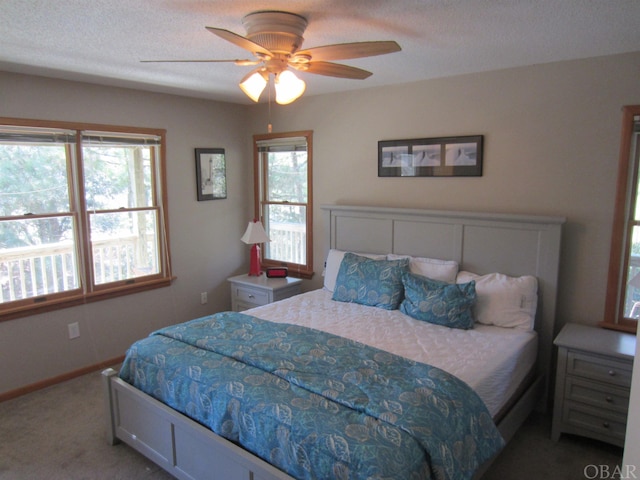 bedroom featuring carpet, baseboards, ceiling fan, and a textured ceiling