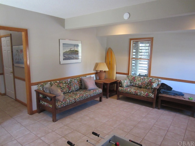 living area featuring light tile patterned floors and beamed ceiling