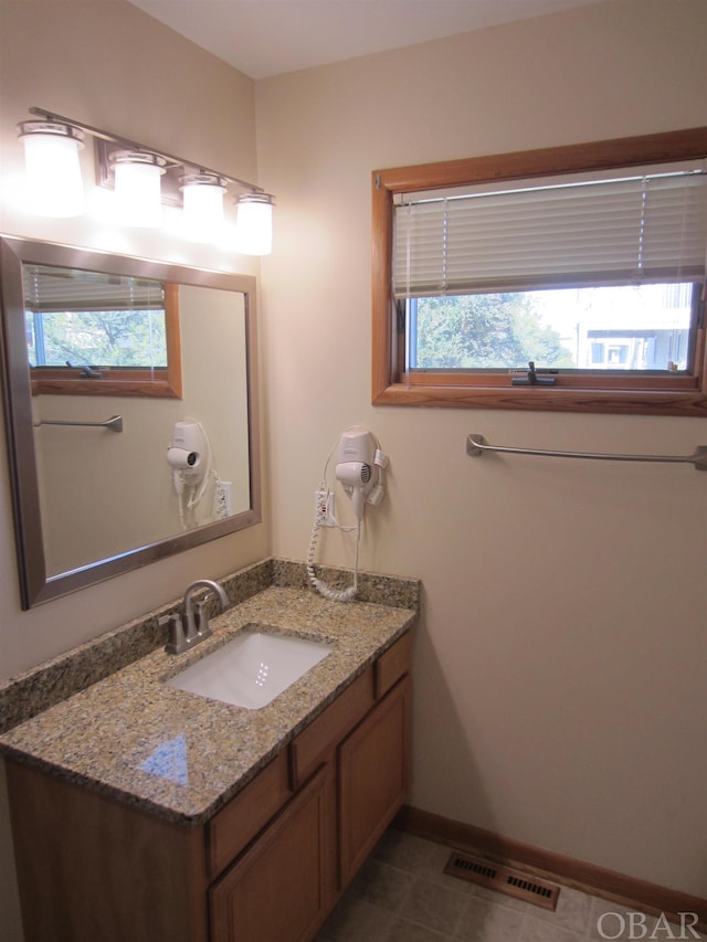 bathroom featuring tile patterned floors, vanity, visible vents, and baseboards