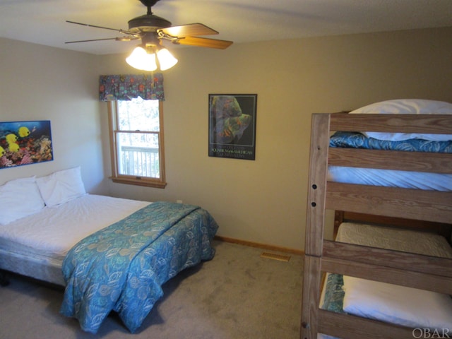 carpeted bedroom featuring visible vents, baseboards, and a ceiling fan