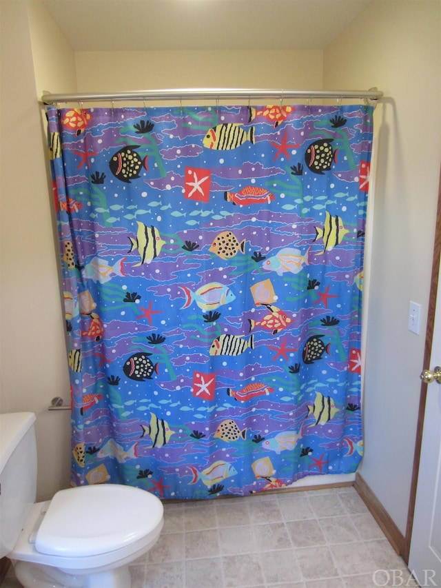 full bath with a shower with curtain, baseboards, and toilet