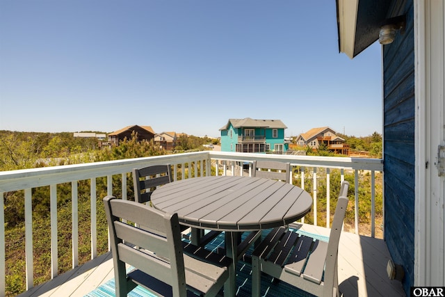 view of wooden balcony featuring a residential view, outdoor dining area, and a deck