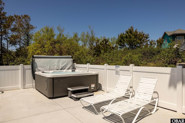 view of patio with fence and a hot tub